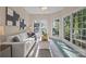 Cozy sun room with large windows and natural light features a white sofa and patterned rug at 263 Fernbrook Dr, Mooresville, NC 28117