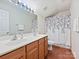 Bathroom with double sink vanity, wood floor and a shower with decorative curtain at 2731 Meadow Knoll Dr, Charlotte, NC 28269