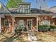 Charming brick home features a covered entryway with hanging flower baskets and a well-maintained front yard at 2731 Meadow Knoll Dr, Charlotte, NC 28269