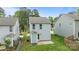 A rear view of a lovely home with light siding, a small patio and green grass at 2821 Shamrock Dr, Charlotte, NC 28205