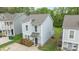 An eye-level view of a light-sided home with a driveway and manicured landscaping at 2821 Shamrock Dr, Charlotte, NC 28205