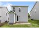 A rear view of a lovely home featuring light siding, green grass and a door at 2821 Shamrock Dr, Charlotte, NC 28205
