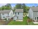 A rear view of modern homes with light siding, a small patio and fenced-in yards at 2821 Shamrock Dr, Charlotte, NC 28205