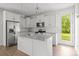 Well-lit kitchen featuring stainless appliances, an island with granite countertops, and a door to the outside at 2821 Shamrock Dr, Charlotte, NC 28205
