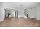 Open-concept living space with hardwood floors, a staircase, and a view of the modern kitchen at 2821 Shamrock Dr, Charlotte, NC 28205