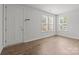 Bright living room with hardwood floors, white walls, and multiple windows for ample natural light at 2821 Shamrock Dr, Charlotte, NC 28205