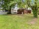 Spacious backyard with mature trees, a lawn, and a brick home with a back door and small porch at 330 Clover St, Mooresville, NC 28115