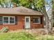 A cozy brick home with manicured lawn, flowering bushes, and an inviting front door at 330 Clover St, Mooresville, NC 28115