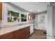 Updated kitchen features wood cabinets, a double sink, laminate counters and a window offering a view of the neighborhood at 330 Clover St, Mooresville, NC 28115