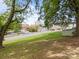 View of a grassy yard and the neighborhood streets, trees, and nearby buildings at 330 Clover St, Mooresville, NC 28115
