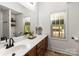Bathroom featuring a double vanity with wood cabinets, a shower, and natural light at 3509 Seminole Dr, Maiden, NC 28650