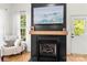 Contemporary fireplace design with a wooden mantel and mounted TV in a bright living space at 3509 Seminole Dr, Maiden, NC 28650