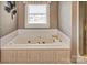 Bathroom with jacuzzi tub, white tile surround, and warm lighting, perfect for relaxation at 378 Shoreline Dr, New London, NC 28127