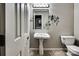 Bathroom featuring a pedestal sink, toilet, accent lighting above the mirror, and decorative wall art at 378 Shoreline Dr, New London, NC 28127