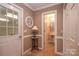 Entryway with tiled floor leading to a bathroom, showcasing neutral tones and a decorative mirror at 378 Shoreline Dr, New London, NC 28127