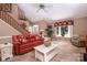 Inviting living room with tile floors, a red sofa, staircase, and a bright window at 378 Shoreline Dr, New London, NC 28127