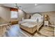 Spacious main bedroom with a large bed, stylish bench, wood floors and neutral tones at 378 Shoreline Dr, New London, NC 28127