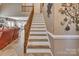 Elegant staircase with wood and white accents, leading to upper level with decorative wall art at 378 Shoreline Dr, New London, NC 28127