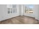 Sunlit bedroom with hardwood floors, white walls and large windows providing natural light and view of the outdoors at 433 Blairhill Rd # 08, Charlotte, NC 28217