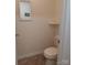 Small bathroom features a toilet, a shelf, tiled floor, and a decorative wall mirror at 4330 Goodman Lake Rd, Salisbury, NC 28146
