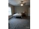 A cozy bedroom with neutral walls, plush carpet, a ceiling fan, and a comfortable bed near a window at 4330 Goodman Lake Rd, Salisbury, NC 28146