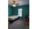 Bright bedroom featuring teal walls, neutral carpet, ceiling fan, and natural light from the window at 4330 Goodman Lake Rd, Salisbury, NC 28146