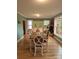 Well-lit dining room with views to the back porch, classic chandelier, and seating for six at 4330 Goodman Lake Rd, Salisbury, NC 28146
