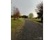 Long, gravel driveway leading to the property, bordered by mature trees and green lawns at 4330 Goodman Lake Rd, Salisbury, NC 28146