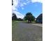 Gravel driveway leading to the house, bordered by green grass and mature trees at 4330 Goodman Lake Rd, Salisbury, NC 28146