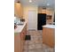 Bright kitchen featuring tan tile, light wood cabinets, marble countertops, island, and black refrigerator at 4330 Goodman Lake Rd, Salisbury, NC 28146