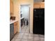 Bright kitchen featuring tan tile, pantry, light wood cabinets, marble countertops, and black refrigerator at 4330 Goodman Lake Rd, Salisbury, NC 28146