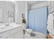 Bathroom with a white vanity, toilet, and shower with a blue curtain, creating a clean and functional space at 4607 Walking Path Dr, Waxhaw, NC 28173