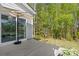 Relaxing patio with a sliding glass door, umbrella, and view of a lush, wooded backyard at 4607 Walking Path Dr, Waxhaw, NC 28173