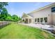 A spacious backyard featuring a covered patio, lush lawn, and private surroundings at 5028 Whitemarsh Ct, Indian Land, SC 29720
