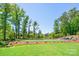 Backyard with lush green lawn, trees, featuring a putting green and seating area at 5028 Whitemarsh Ct, Indian Land, SC 29720
