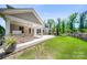 Backyard featuring a covered patio with built-in grill, fireplace, and lush lawn, perfect for outdoor enjoyment at 5028 Whitemarsh Ct, Indian Land, SC 29720