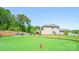 A stunning backyard with putting green, patio, and lush landscaping perfect for entertaining or relaxing outdoors at 5028 Whitemarsh Ct, Indian Land, SC 29720