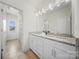 Bathroom with a granite countertop, vanity, a large mirror, and a view into an adjacent bath area at 5028 Whitemarsh Ct, Indian Land, SC 29720