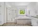 Bright bathroom featuring a soaking tub, separate shower, and large window offering scenic views at 5028 Whitemarsh Ct, Indian Land, SC 29720