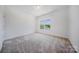 Bright bedroom with plush carpeting and a large window offering neighborhood views at 5028 Whitemarsh Ct, Indian Land, SC 29720