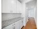 Conveniently located butler's pantry with granite countertop and white subway tile backsplash, providing extra storage at 5028 Whitemarsh Ct, Indian Land, SC 29720