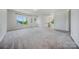 Expansive living room with plush carpeting, large windows, and ample natural light at 5028 Whitemarsh Ct, Indian Land, SC 29720