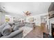 Open living area with large gray sectional, fireplace, high ceilings, and views into the kitchen at 5028 Whitemarsh Ct, Indian Land, SC 29720