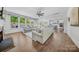 Bright living room featuring fireplace, large sectional, wood floors and an open floorplan to kitchen at 5028 Whitemarsh Ct, Indian Land, SC 29720