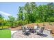 Beautiful outdoor patio with stone pavers, seating, fire pit, and lush landscaping creates a relaxing outdoor living space at 5028 Whitemarsh Ct, Indian Land, SC 29720