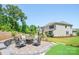 A beautiful patio with pavers, fire pit, and furniture overlooks the house and backyard putting green at 5028 Whitemarsh Ct, Indian Land, SC 29720
