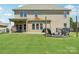 Large backyard features a covered porch and a stone patio with a firepit and outdoor seating at 5037 Nighthawk Dr, Fort Mill, SC 29707