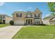 Charming two-story brick home with a well-manicured lawn and attached two-car garage at 5037 Nighthawk Dr, Fort Mill, SC 29707