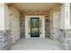 Close-up of a covered front porch with brick and stone accents and a black-framed glass door at 5037 Nighthawk Dr, Fort Mill, SC 29707