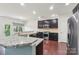 Spacious kitchen features stainless steel appliances, a breakfast bar, dark wood cabinets and hardwood floors at 5037 Nighthawk Dr, Fort Mill, SC 29707